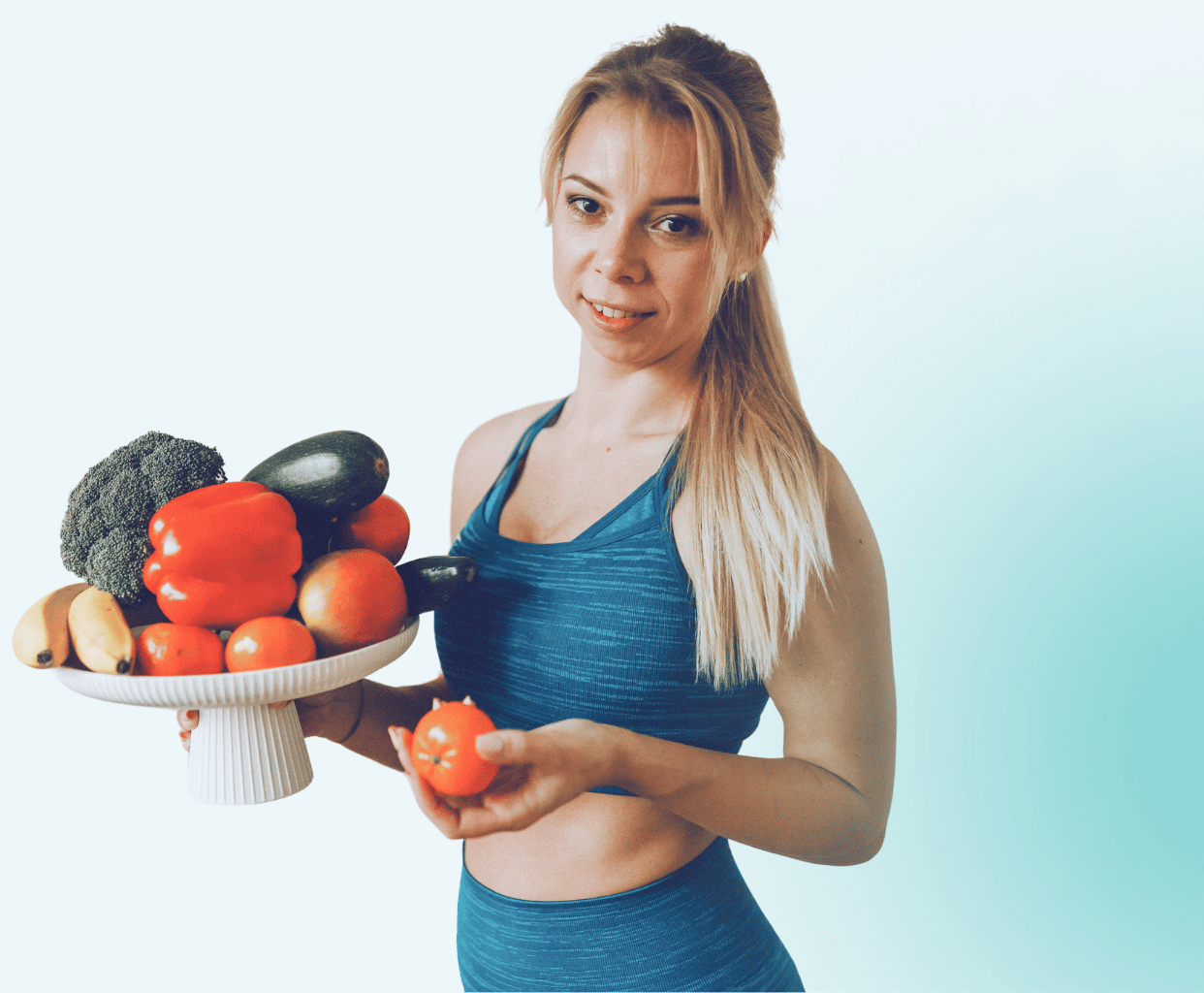 Uśmiechnięta Aleksandra Rodak w ciemnoniebieskim stroju fitness trzymająca tortownicę pełną warzyw i zdrowego jedzenia