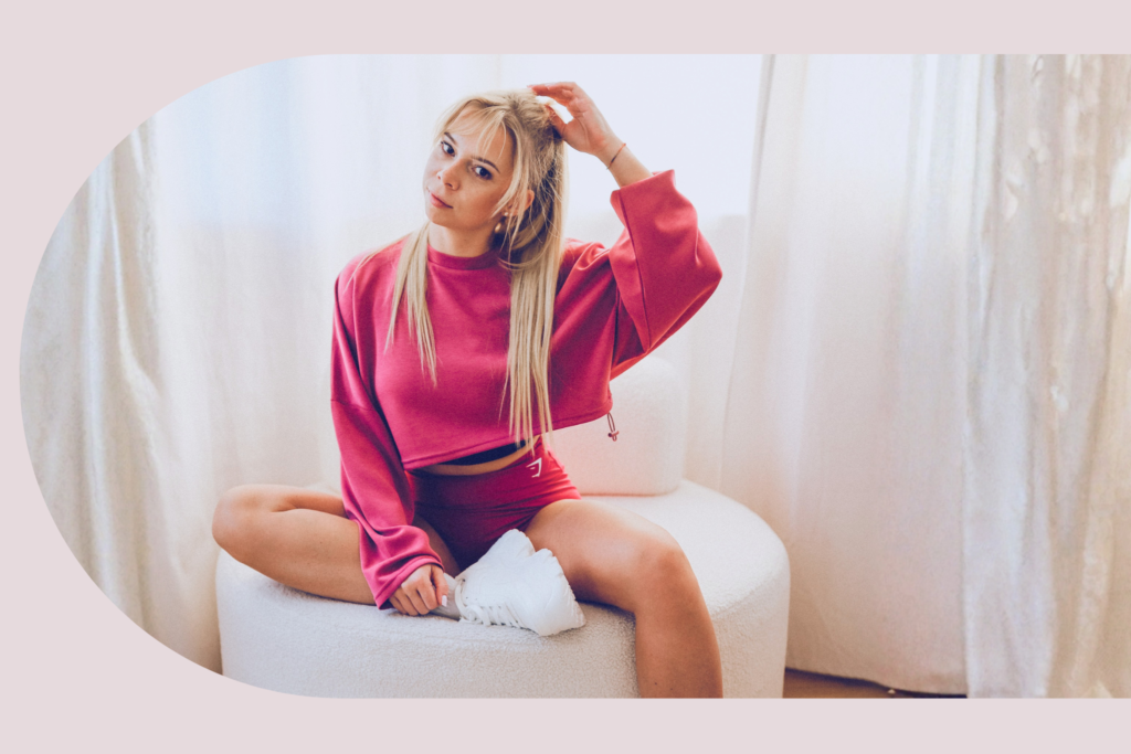 Aleksandra Rodak w różowym sportowym stroju siedząca na fotelu